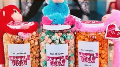 Colorful kettle corn jars with decorative toppers and branded labels.