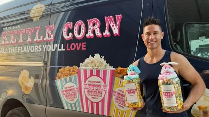 A man holding decorated popcorn jars beside The Original Kettle Corn Maker van.